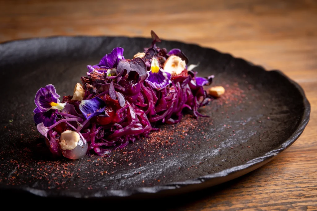 A Cuculia creation with purple vegetables and flowers