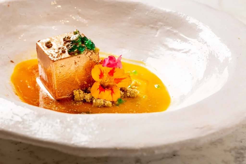 A Cuculia creation with a golden sauce and flowers